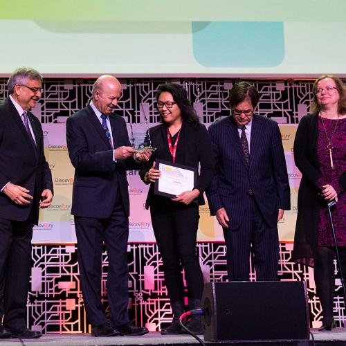 Reza Moridi, Ontario's minister of innovation, research and science, presents an award to U of T's Luna Yu (centre), the founder and CEO of Genecis EnviroTech, at this year's Discovery conference (photo by Chris Sorensen) 