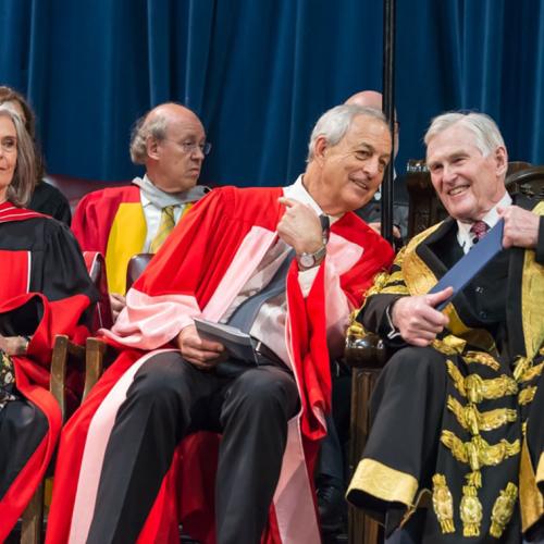 Geoffrey Matus, who received an honorary doctor of laws, honoris causa, on Wednesday, speaks to U of T Chancellor Michael Wilson at the convocation ceremony (photo by Steve Frost) 