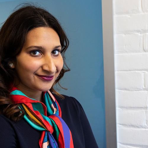 Leila Keshavjee smiles at camera while standing in a doorway (photo by Chris Sorensen) 