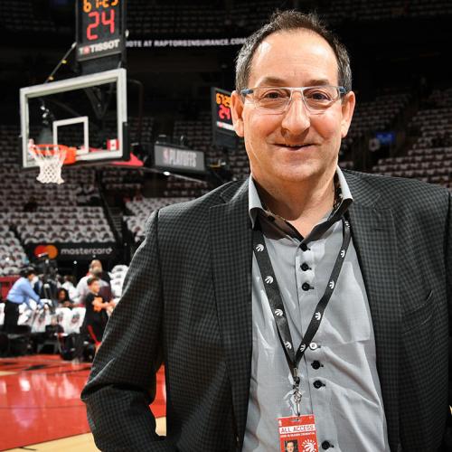 Dr. Howard Petroff smiles as he stands by the edge of the Raptors' basketball court.
