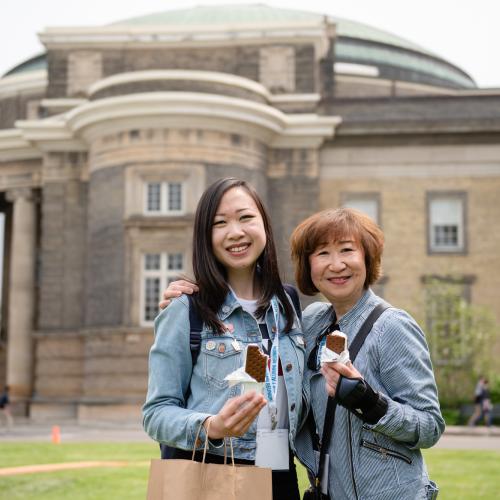 Mother and daughter enjoying ice cream sandwiches in front of Convocation Hall