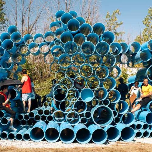 Visitors climb on the Futurity Island sonic artwork - dozens of massive water pipes piled three metres high like a 3D pan pipe.