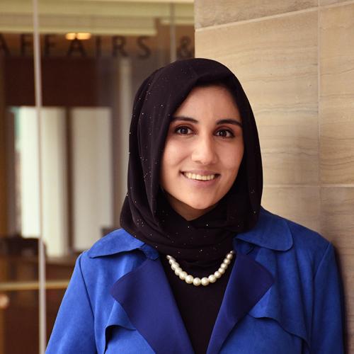 Rehona Zamani smiles, standing in a doorway.