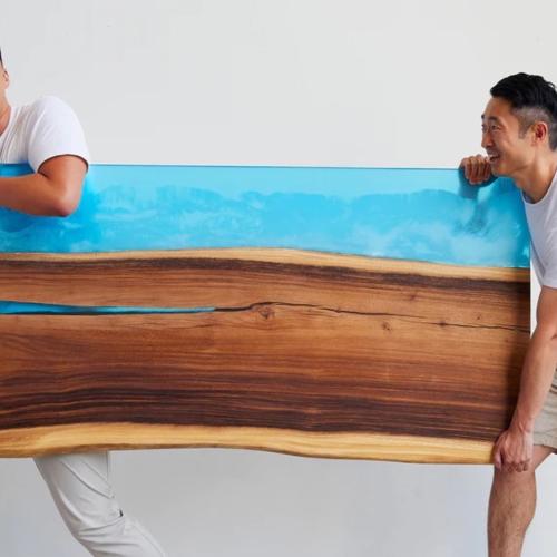 The Risedesk founders carrying a desk
