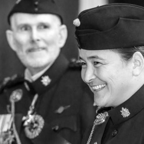 Vicky Sunohara smiles while wear a military hat and uniform with insignia on the collar.