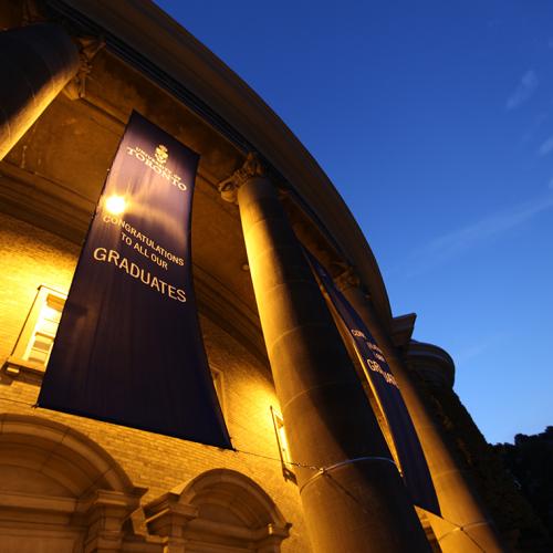 Convocation Hall glows at dusk. The banner reads: Congratulations to all our graduates.