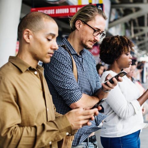 Commuters are absorbed in their smartphones on a train platform (photo by rawpixel via Unsplash) 