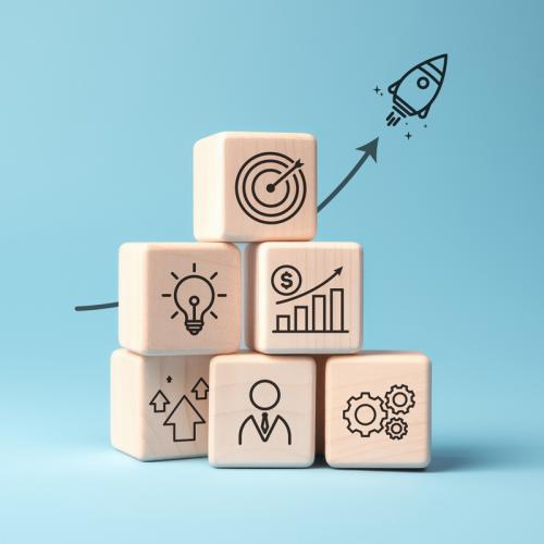 Rocket launching from wood cube with business icons such as Start-up, Creativity, and Big idea.