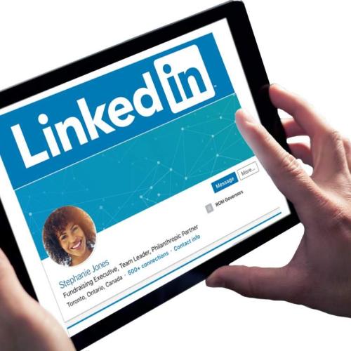 Tablet held to view LinkedIn profile webpage