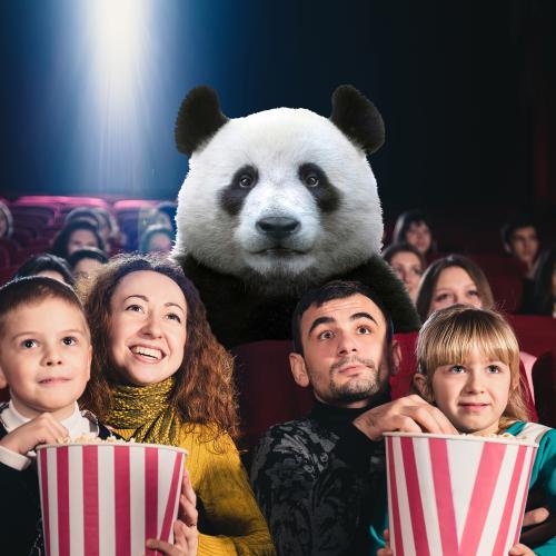 A family watching a movie with a panda in a theatre