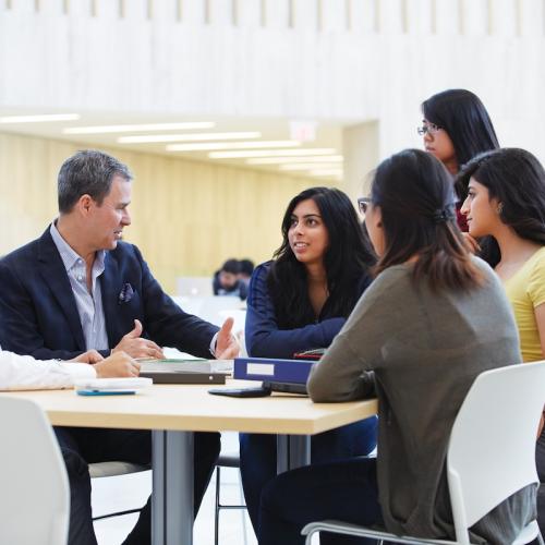 Image of people around a table having a discussion. 