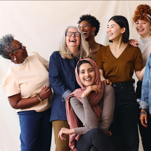 Group of women laughing as they pose for a picture together