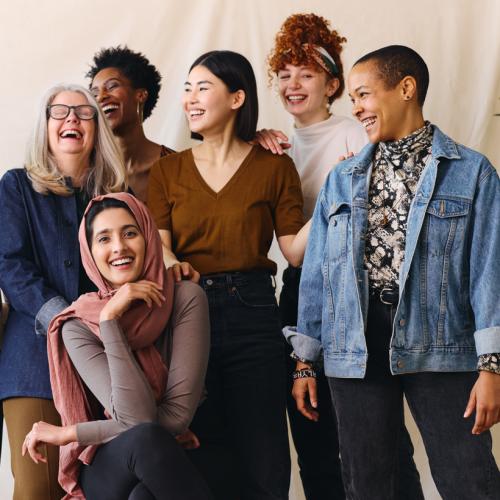 Group of women laughing as they pose for a picture together
