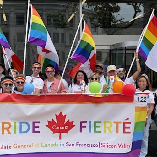 People celebrating Pride, holding a banner that reads "Pride - Fierte" and "Consulate General Consulate General of Canada in San Francisco | Silicon Valley"