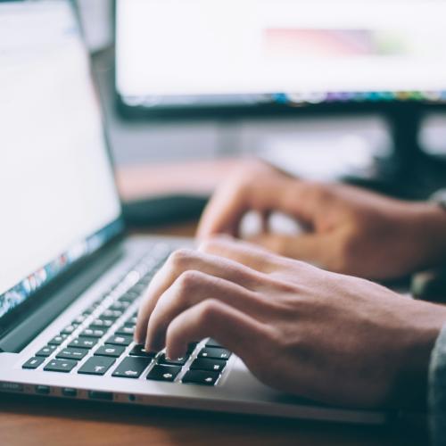 A person typing on the computer keyboard