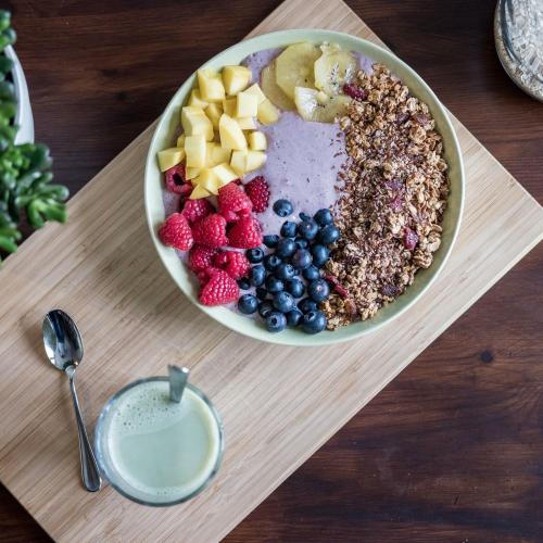 bowl of fruit on a table with a spoon
