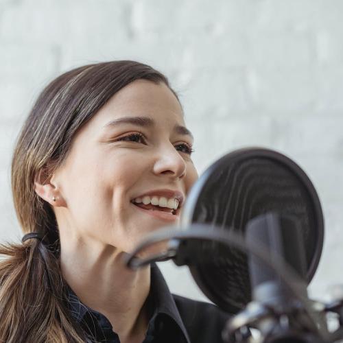 Woman speaks into microphone with smile