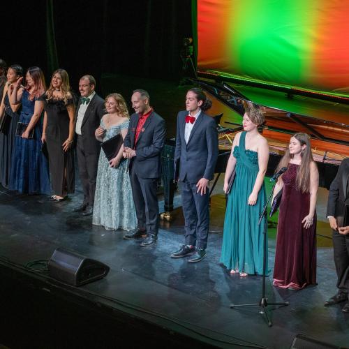 Singers standing in a row on stage at the end of the concert