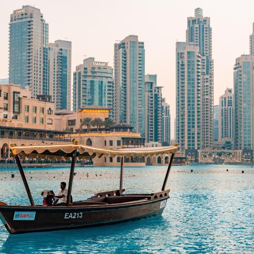 Dubai scene with boat in water and buildings in the background