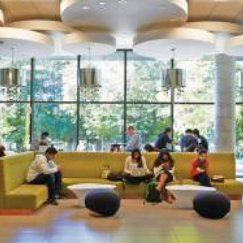 Students sitting and using computers and smart phones