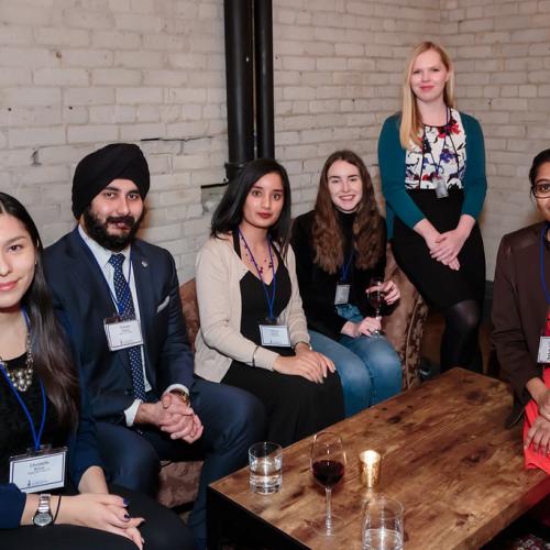 Group of alumni sitting at a lounge table.
