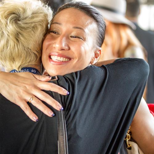 Two female alumni hugging